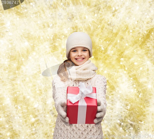 Image of dreaming girl in winter clothes with gift box