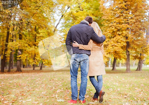 Image of couple hugging in autumn park from back