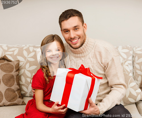 Image of smiling father and daughter holding gift box