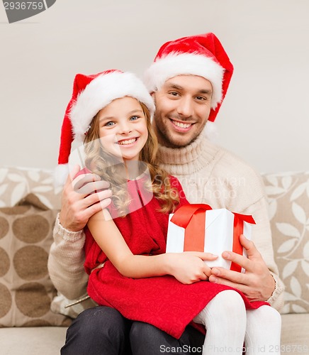 Image of smiling father and daughter holding gift box