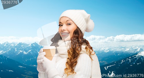 Image of smiling young woman in winter clothes with cup