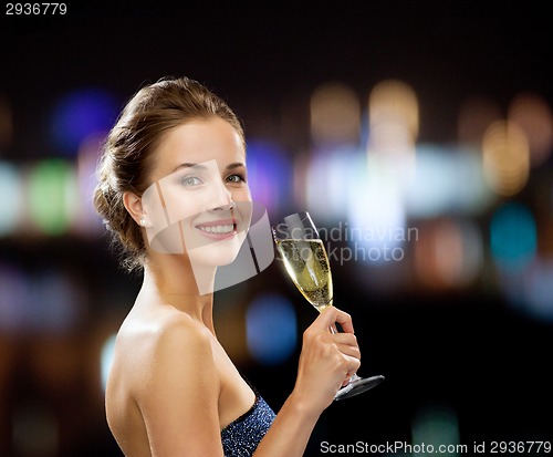 Image of smiling woman holding glass of sparkling wine