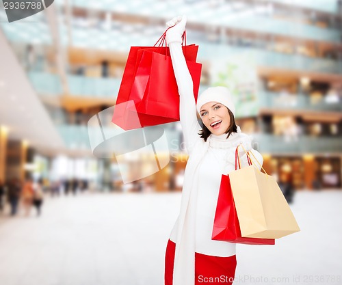 Image of smiling young woman with red shopping bags