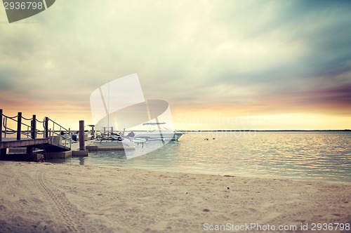 Image of boats moored to pier at sundown