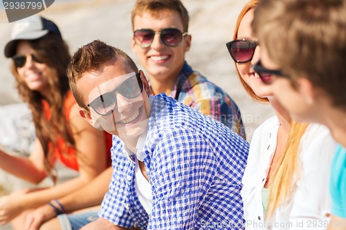 Image of close up of smiling friends sitting on city street