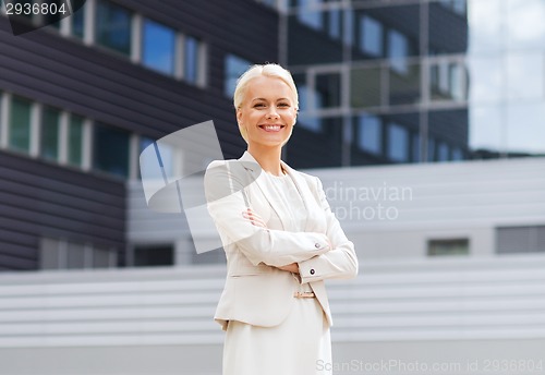 Image of young smiling businesswoman with crossed arms