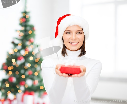 Image of smiling woman in santa helper hat with gift box