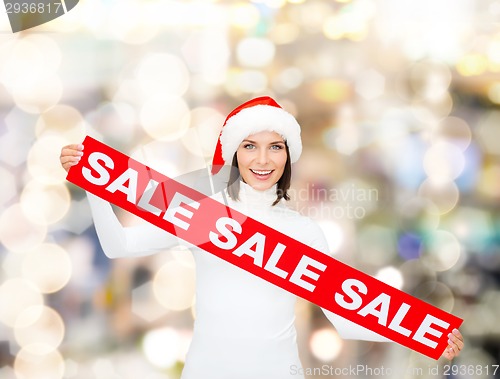 Image of smiling woman in santa helper hat with sale sign
