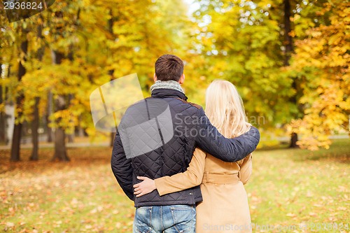 Image of couple hugging in autumn park from back