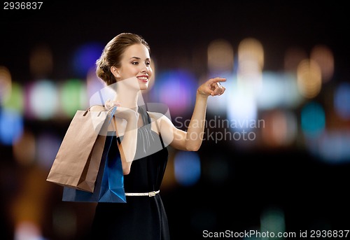 Image of smiling woman in dress with shopping bags