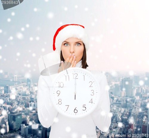 Image of woman in santa helper hat with clock showing 12