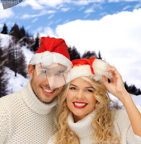 Image of smiling couple in sweaters and santa helper hats