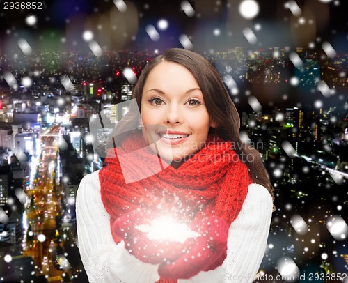 Image of smiling woman in winter clothes with snowflake