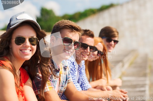 Image of close up of smiling friends sitting on city street