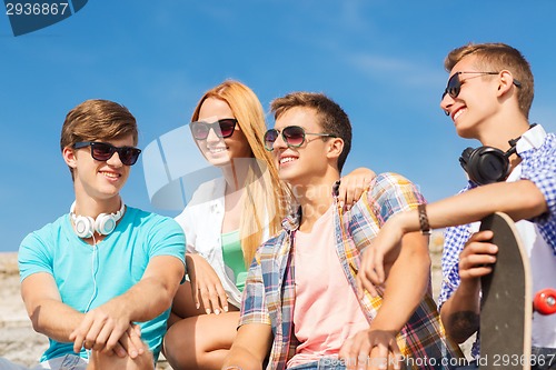Image of group of smiling friends sitting on city street