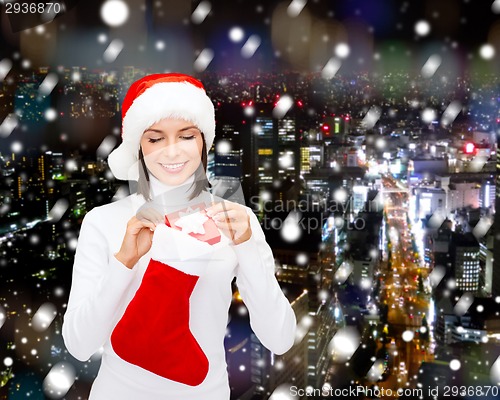 Image of woman in santa hat with gift box and stocking