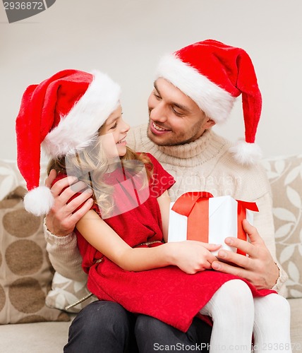 Image of smiling father and daughter holding gift box