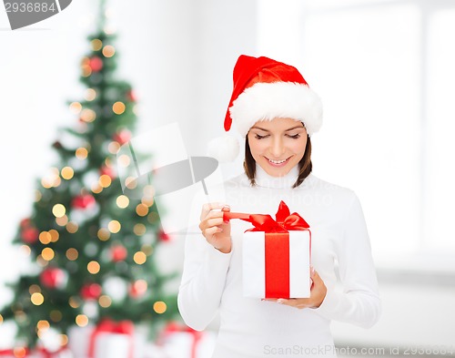 Image of smiling woman in santa helper hat with gift box