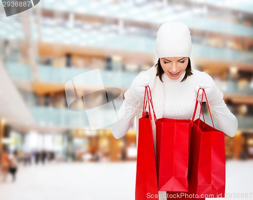 Image of smiling young woman with red shopping bags