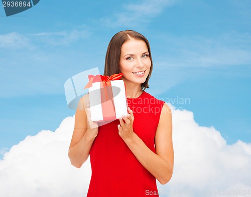 Image of smiling woman in red dress with gift box