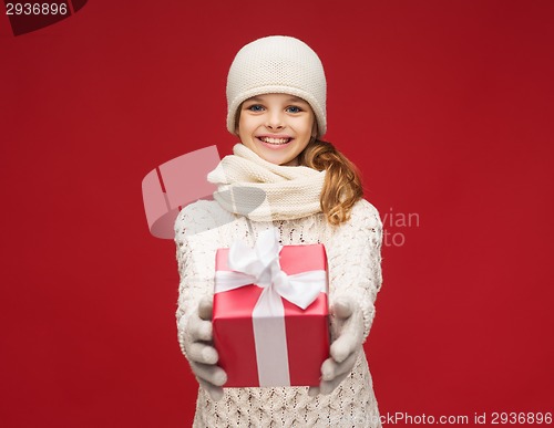 Image of girl in hat, muffler and gloves with gift box