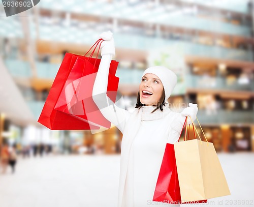 Image of smiling young woman with red shopping bags