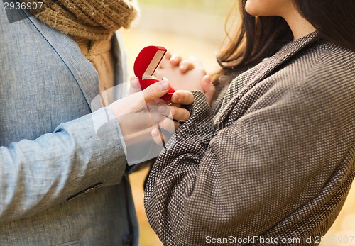 Image of close up of couple with gift box in park