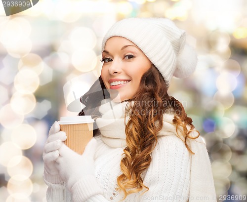 Image of smiling young woman in winter clothes with cup