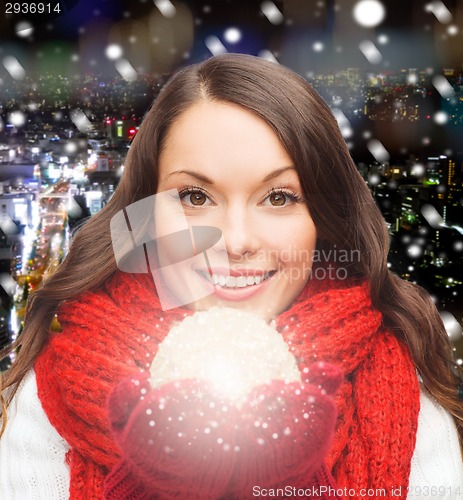 Image of smiling woman in winter clothes with snowball