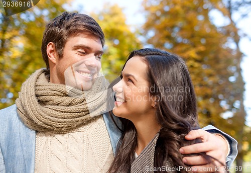 Image of smiling couple hugging in autumn park