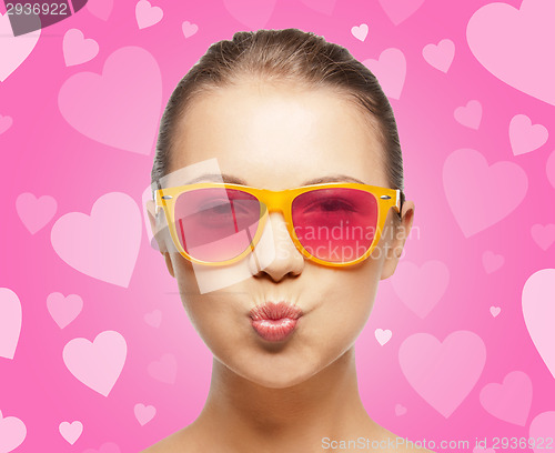 Image of girl in pink sunglasses blowing kiss