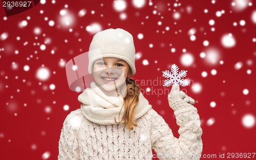 Image of smiling girl in winter clothes with big snowflake