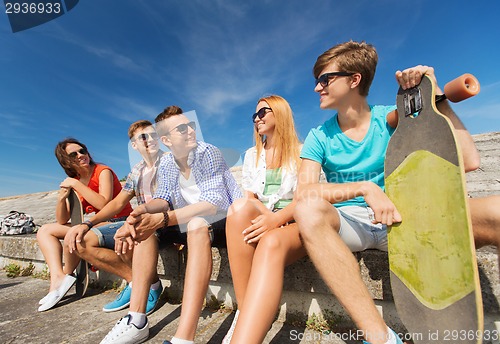 Image of group of smiling friends sitting on city street