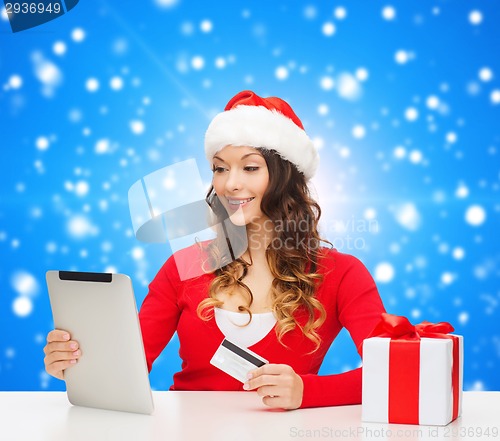 Image of smiling woman with credit card and tablet pc