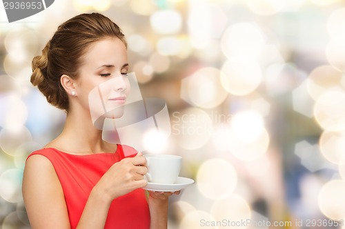 Image of smiling woman in red dress with cup of coffee