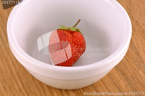 Image of bowl with strawberries on wood background