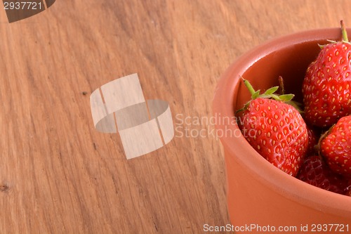Image of close up of small strawberry on wood