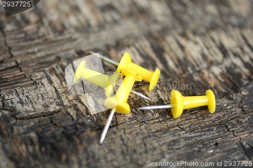 Image of yellow push pins on old wooden background