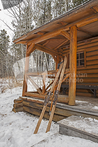 Image of vintage skis and log cabin