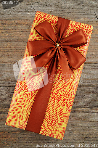 Image of beautifully decorated gift box with bow on wooden