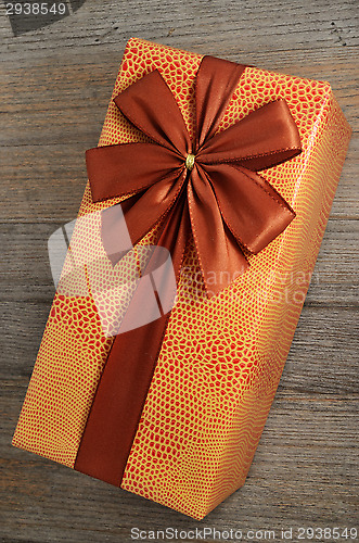 Image of beautifully decorated gift box with bow on wooden