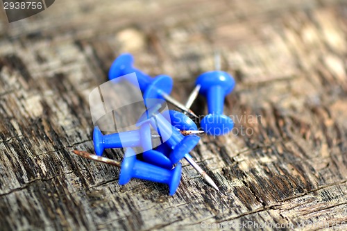 Image of blue push pins on old wooden background
