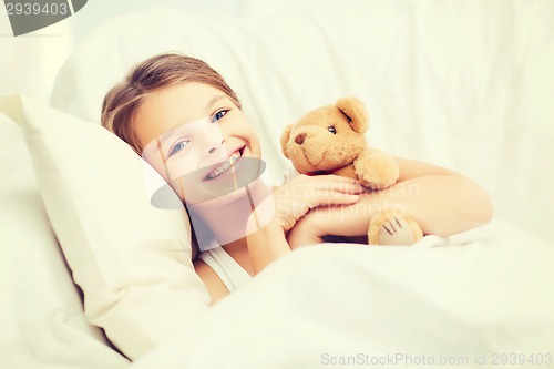 Image of little girl with teddy bear sleeping at home