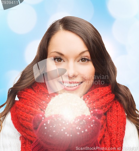 Image of smiling woman in winter clothes with snowball