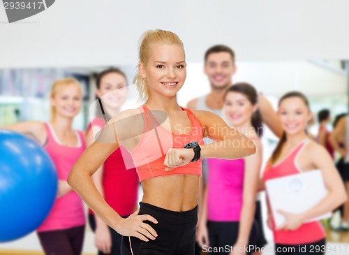 Image of smiling woman with heart rate monitor on hand