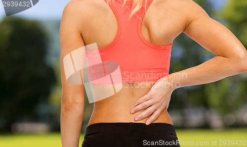 Image of close up of sporty woman touching her back