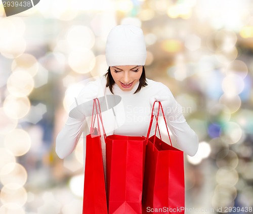 Image of smiling young woman with red shopping bags