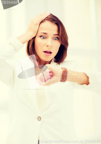 Image of stressed businesswoman looking at clock