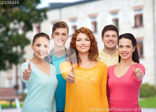 Image of group of smiling teenagers over campus background
