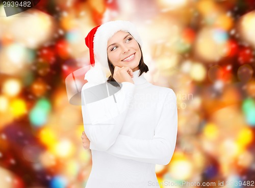 Image of thinking and smiling woman in santa helper hat